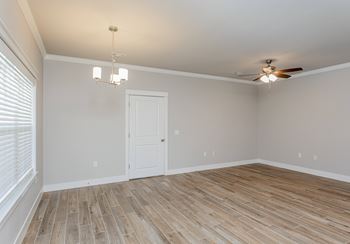 A room with a ceiling fan and a door.
